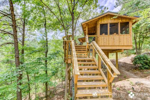 a tree house in the woods with stairs at The Cottonwood in Treehouse Grove at Norton Creek in Gatlinburg