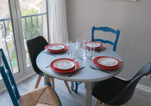 uma mesa com pratos e utensílios vermelhos e brancos em Chill and Work entre Paris et Disney em Neuilly-Plaisance