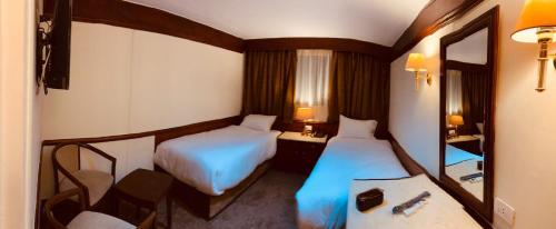 Habitación de hotel con 2 camas y espejo en Prince Omar Nile Cruise - Luxor to Aswan, en Asuán