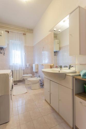 a large bathroom with two sinks and a toilet at Spacious and bright apartment- Silvio 1 in Banjole