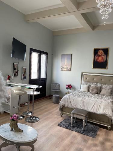 a bedroom with a bed and a table in it at The Balconies Studio, The Marilyn Suite & The Crystal Apartment at Casa of Essence in Old San Juan in San Juan