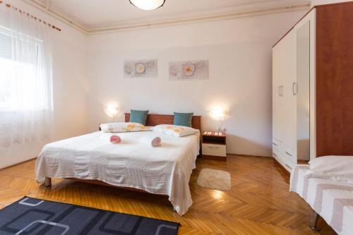 a white bedroom with a large white bed and a window at Spacious and bright apartment- Silvio 1 in Banjole