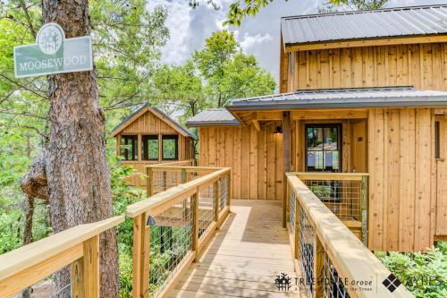 a wooden walkway leading to a house with a tree at The Moosewood in Treehouse Grove at Norton Creek in Gatlinburg