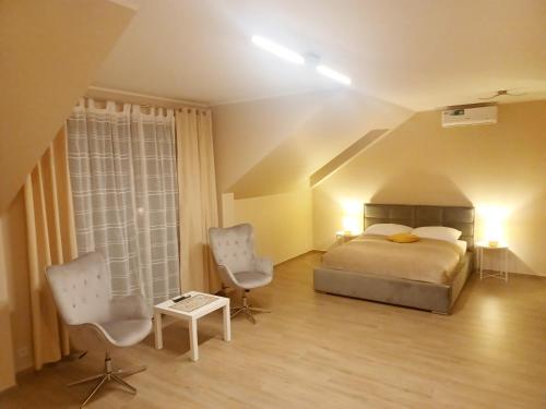 a bedroom with a bed and two chairs at AJP Prestige House Szczecin Załom in Szczecin