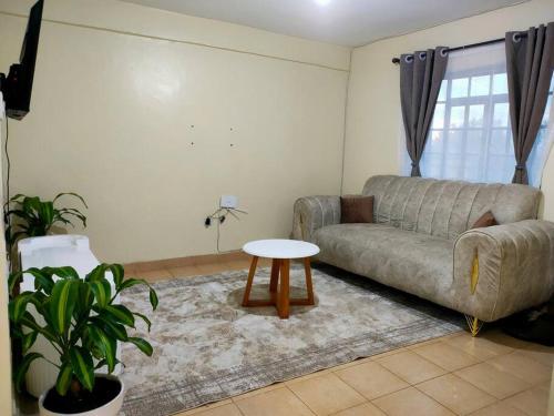 a living room with a couch and a table at Fancy One Bedroom Juja in Juja