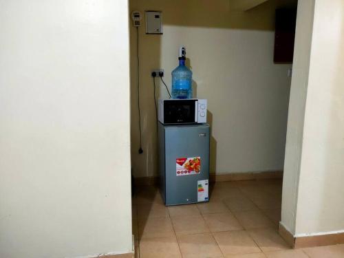 a bottle of water sitting on top of a refrigerator at Fancy One Bedroom Juja in Juja
