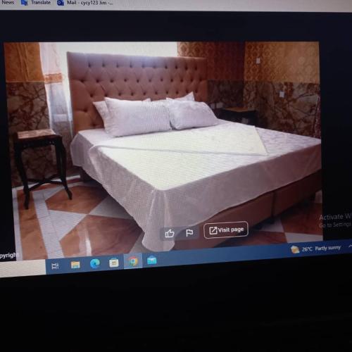 a tv screen with a bed in a room at Grand Emperor Museum Hotels and Resorts in Lekki
