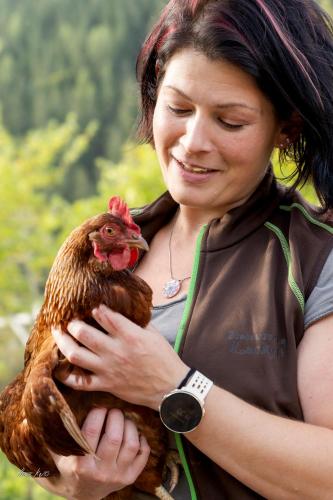 a woman holding a chicken in her hands at Biobauernhof Lacken in Strohmarkt