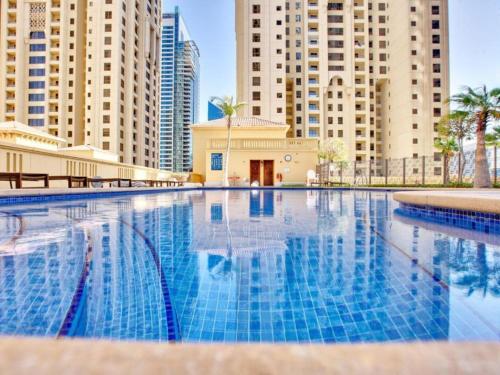 una piscina en una ciudad con edificios altos en Arabian Nights Beach Hostel, en Dubái