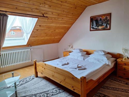 a bedroom with a large wooden bed in a attic at Vila Gabriel in Nová Lesná