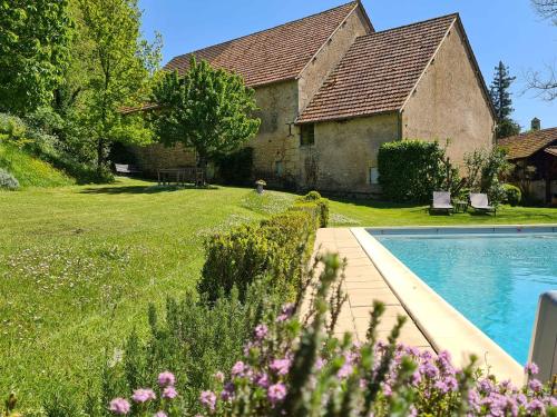 une maison avec une piscine en face d'une cour dans l'établissement Ferme de Tayac - Charme avec Pool, à Les Eyzies-de-Tayac