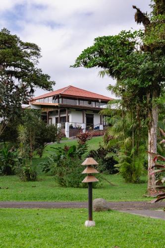 a house with a bird bath in the grass at Villa Blanca Cloud Forest Hotel & Retreat in San Ramón
