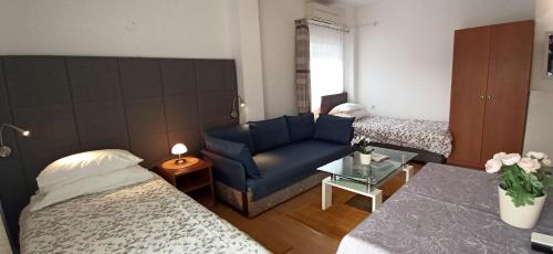 een woonkamer met een blauwe bank en een bed bij OK studio & rooms Lipik in Lipik
