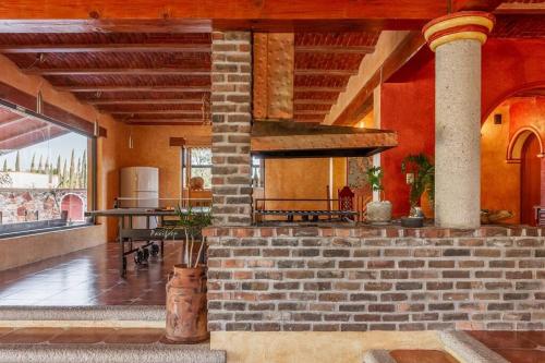 a room with a brick oven in a building at Hermosa Casa 20p/6Hab/Pool/Jacuzzi Tequisquiapan in La Laja