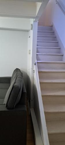 a room with a staircase with a couch and a stair case at Le 111 Henri in Gatineau