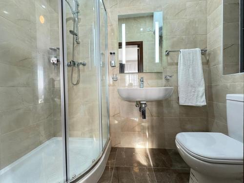 ein Bad mit einer Dusche, einem Waschbecken und einem WC in der Unterkunft BaySide1 Marsaxlokk Malta in Marsaxlokk