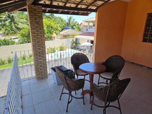 eine Terrasse mit einem Tisch und Stühlen auf dem Balkon in der Unterkunft Casa para temporada in Vera Cruz de Itaparica