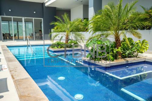 a swimming pool with palm trees in a building at Ambar Roca Santa Marta By CTBNB in Santa Marta