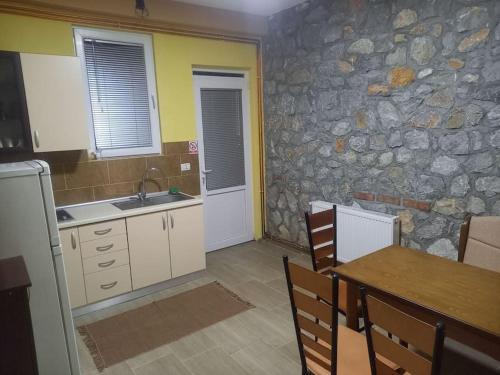 奧赫里德的住宿－Apartment Grazdani，厨房配有桌子和石墙