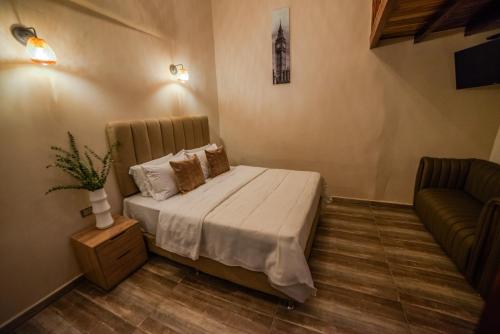 - une chambre avec un lit et un canapé dans l'établissement HOTEL BALI AT POBLADO, à Medellín
