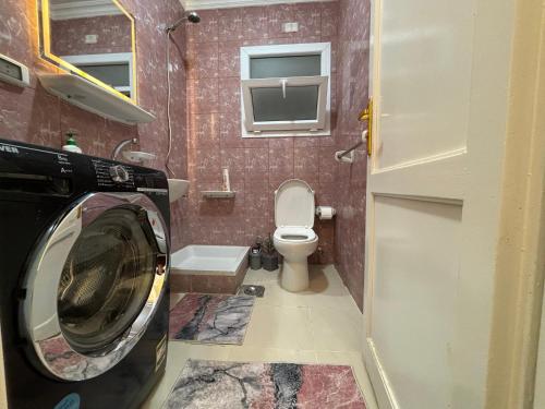 eine Waschmaschine im Bad mit WC in der Unterkunft Luxury Inn:2BR Amazing Garden View in Madinaty B10 in Madinaty