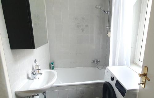 Suite in imperial design, central location في فيينا: حمام أبيض مع حوض وحوض استحمام