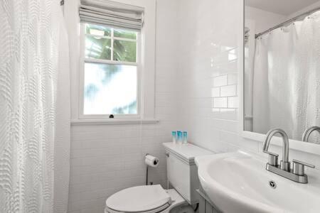 a white bathroom with a toilet and a sink at The Adaline #1 - Upscale Hyde Park Apt, First Floor in Tampa