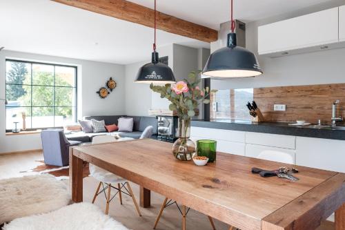 a kitchen and living room with a wooden table at Suite Franz Tegernsee in Tegernsee