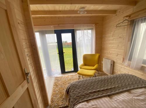 Un pequeño dormitorio con una silla amarilla y una cama en Country Cabin, en Mullagh