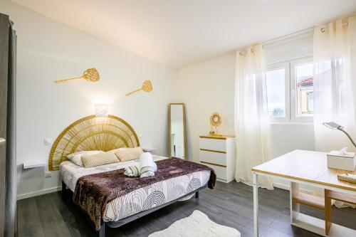 ein Schlafzimmer mit einem großen Bett und einem Tisch in der Unterkunft Le Charles in Montbéliard