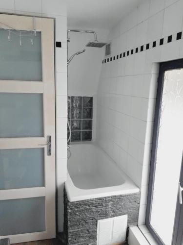 eine Badewanne im Bad mit Fenster in der Unterkunft "Nice House" proche de Disney in Trilport