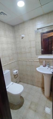 a bathroom with a toilet and a sink at housesuits7 in Sharjah