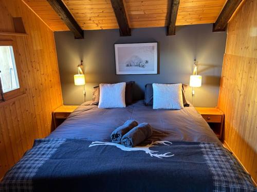 um quarto com uma cama azul com dois cães deitados sobre ela em Chalet traditionnel Haute Nendaz em Nendaz