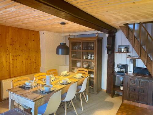 uma sala de jantar com uma mesa de madeira e cadeiras em Chalet traditionnel Haute Nendaz em Nendaz