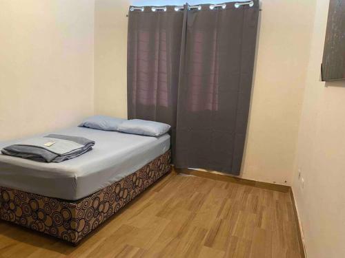 uma pequena cama num quarto com uma cortina roxa em Casa con Alberca en colonia Vista Hermosa em Reynosa