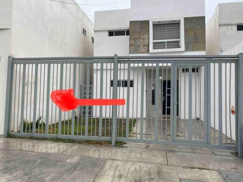 um objecto vermelho está a sair de uma vedação em Casa con Alberca en colonia Vista Hermosa em Reynosa