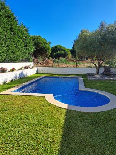 a swimming pool in the middle of a lawn at Sea wave sounds, Meco, by the beach in Sesimbra