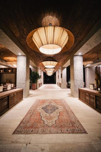 a hallway with a rug on the floor and a large ceiling at Naio Hotel y Villas By OxoHotel in Palomino