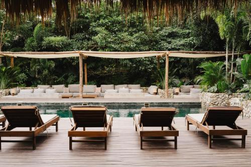 a pool with chaise lounges and chairs in a resort at Naio Hotel y Villas By OxoHotel in Palomino