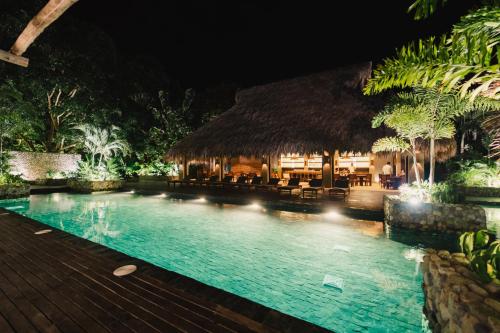 a swimming pool in a resort at night at Naio Hotel y Villas By OxoHotel in Palomino