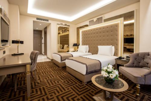 a hotel room with two beds and a desk at Ramada by Wyndham Istanbul Golden Horn in Istanbul