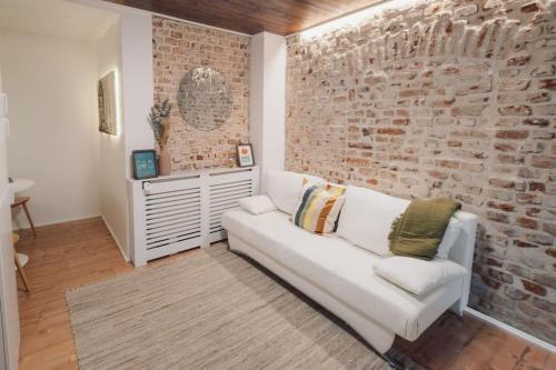 sala de estar con sofá blanco y pared de ladrillo en Suite 13 Loft mit Terrasse, en Teublitz