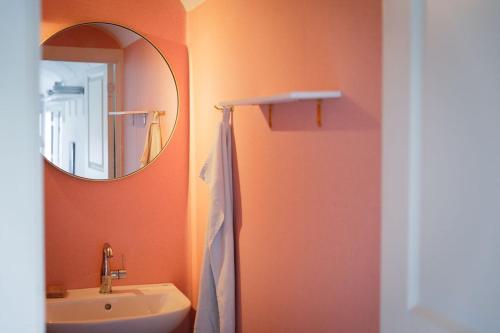 een badkamer met een wastafel en een spiegel bij Cirkusvognen på Ærø in Marstal