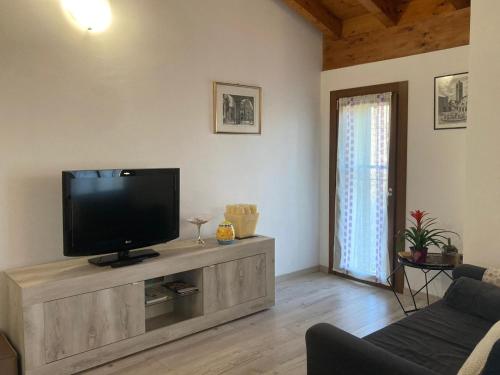 Oasi Verde في Palazzago: غرفة معيشة مع تلفزيون بشاشة مسطحة على خزانة خشبية