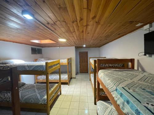 a room with three bunk beds and a wooden ceiling at Residencial Don Santiago in Talca