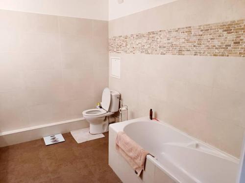 ein weißes Bad mit einer Badewanne und einem WC in der Unterkunft Magnifique Appartement à 500 mètres du Métro in Levallois-Perret