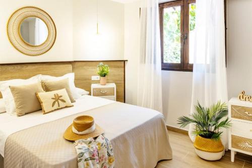 1 dormitorio con 1 cama con sombrero en Precioso apartamento con Jardín a 500m de la Playa en Altafulla