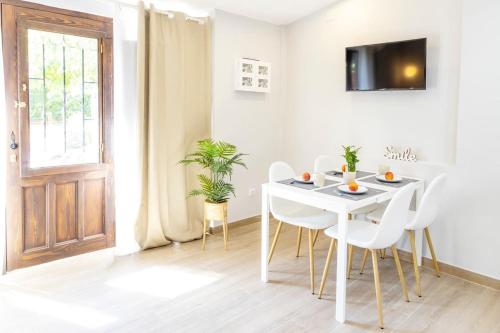 a white dining room with a white table and chairs at Precioso apartamento con Jardín a 500m de la Playa in Altafulla