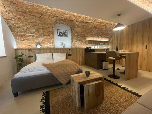 a bedroom with a brick wall and a bed and a desk at UnderStreet studio with private parking in Košice