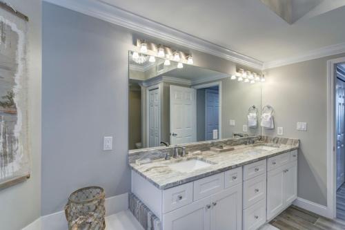 a bathroom with two sinks and a large mirror at St Maarten 308 a Renovated Luxury Beach Front 3 Bedroom 3rd Floor Condo with Resort Amenities in Destin